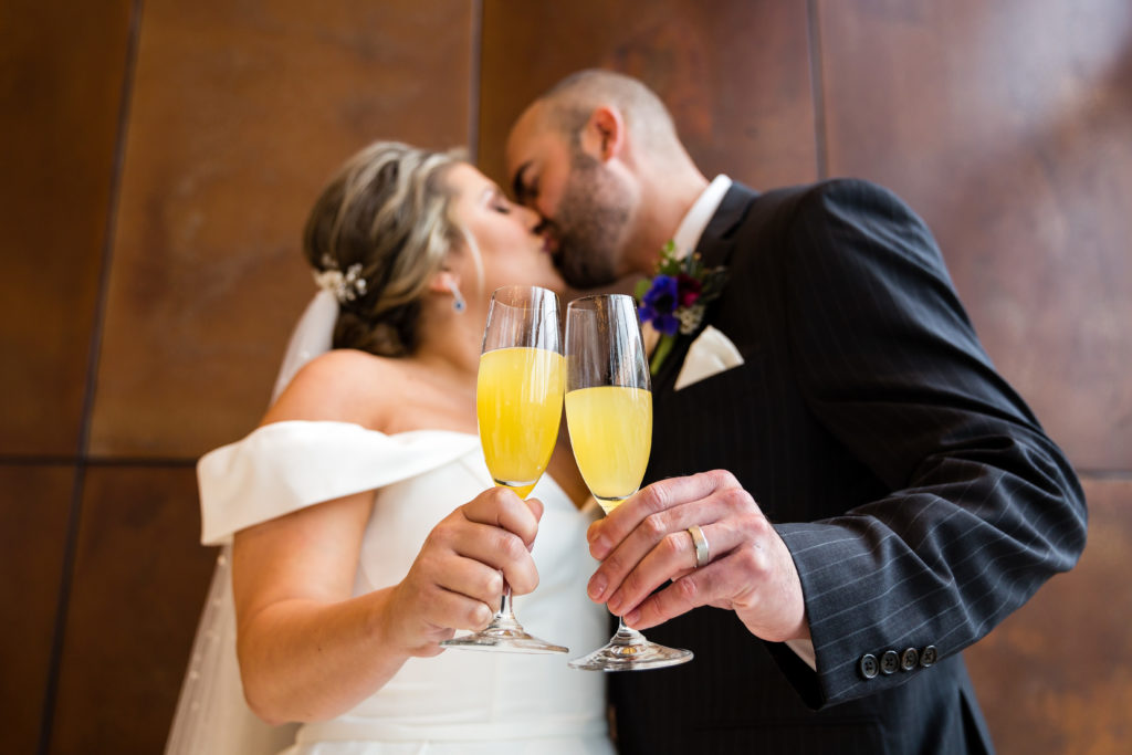 Bride and groom cheers with mimosas