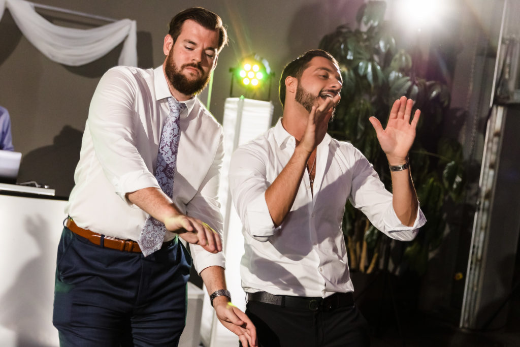 Two wedding guests dance to a DJ at a wedding