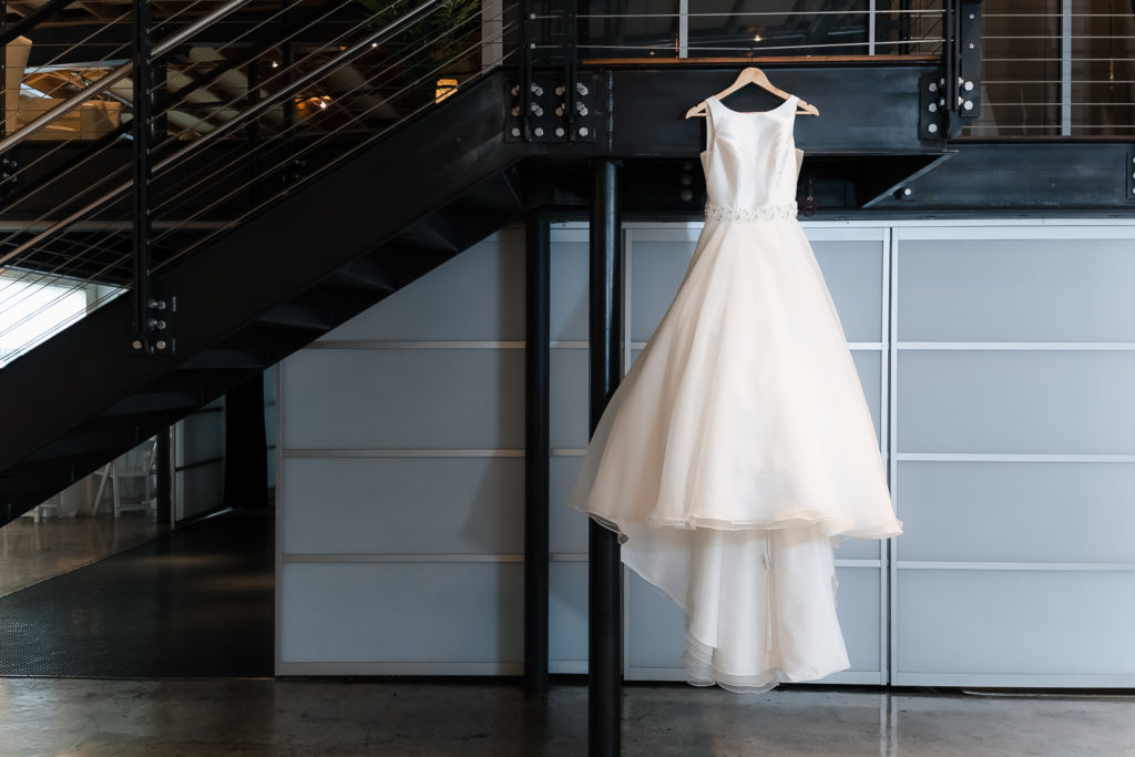 Wedding dress hanging from the second story steps at Zen - an elegant space for hire.