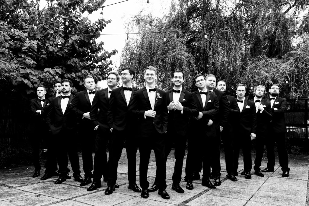 black and white image of the Groom and groomsmen lined up in a "V" formation 