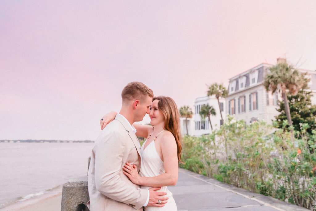 Couple in coordinated neutral engagement outfits along The Battery in Charleston, South Carolina